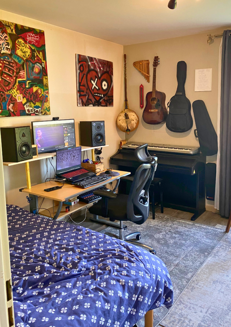 Studio musical optimisé par Home Organizer Nantes HO BLANDINE : aménagement complet avec poste de travail ergonomique, instruments de musique bien disposés au mur, équipement audio professionnel et décoration street art personnalisé. Home Organizer La Baule, experte en organisation d'espaces créatifs Loire-Atlantique.